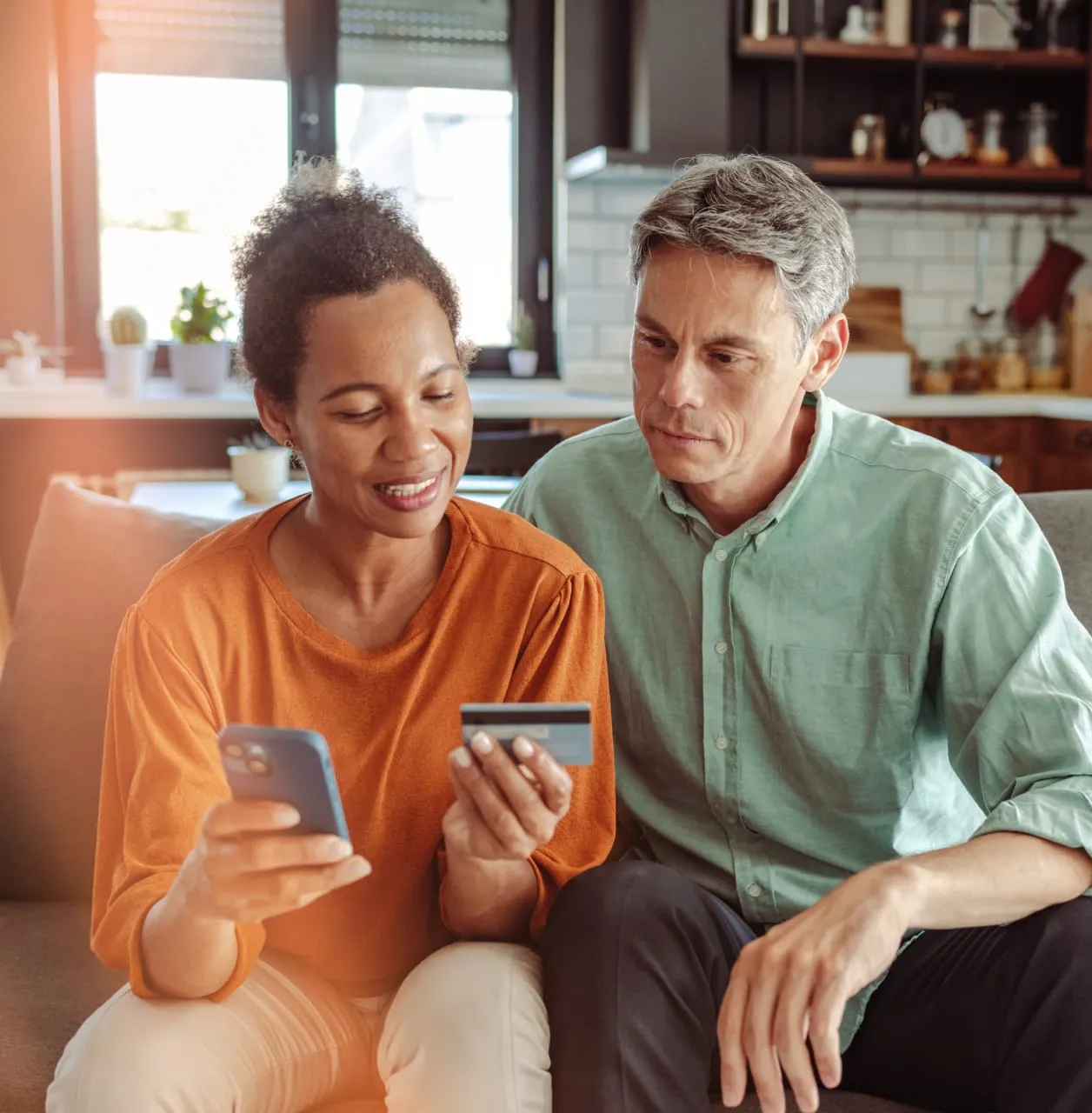 A couple is entering credit card info on a phone