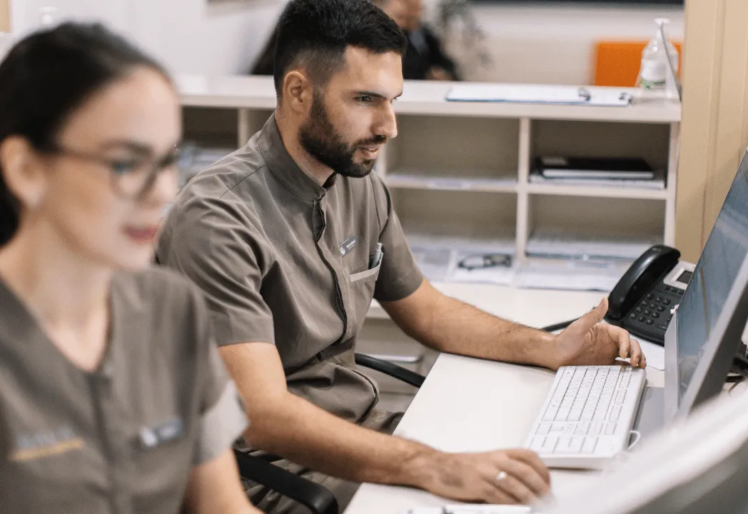 Two colleagues working intently on their computers in a shared office space.